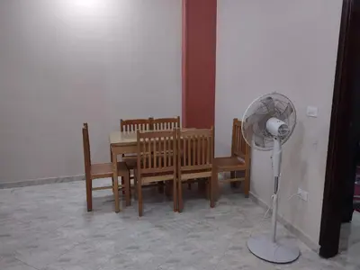 a dining room with a table and chairs and a fan at شقة الغردقة in Hurghada