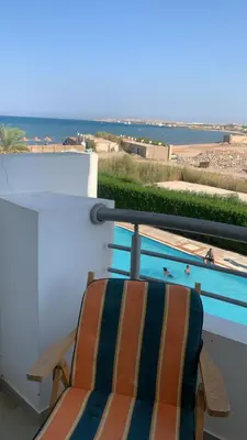 a chair on a balcony with a view of the ocean at Cecelia Resort Hurghada H11 in Hurghada