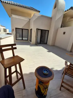 a patio with a table and two chairs in front of a house at Modern simple apartment with roof in Hurghada