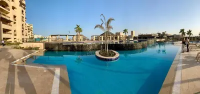 a swimming pool with blue water in a resort at Modern simple apartment with roof in Hurghada