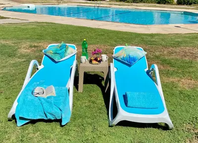 two beds and a table next to a pool at Stella Makadi Bay - Pool View Apartment with Beach Access - Holiday Makadi in Hurghada
