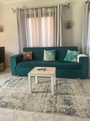 a living room with a blue couch and a coffee table at Stella Makadi Bay - Pool View Apartment with Beach Access - Holiday Makadi in Hurghada