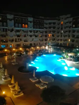 a large swimming pool in front of a building at night at Florenza khamsin Resort Hurghada P109 in Hurghada