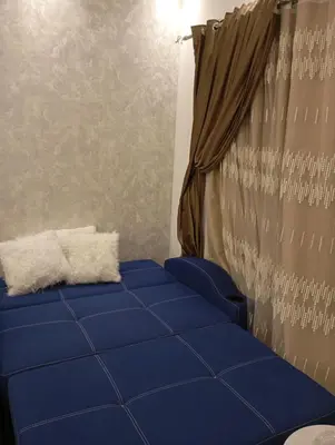 a blue couch in a room with a curtain at Florenza khamsin Resort Hurghada P109 in Hurghada