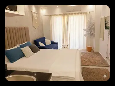 a bedroom with a large white bed with blue pillows at Florenza khamsin Resort Hurghada P109 in Hurghada