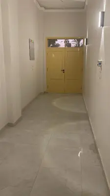 a room with a yellow door and a tile floor at mariam Garden in Al Aqālitah