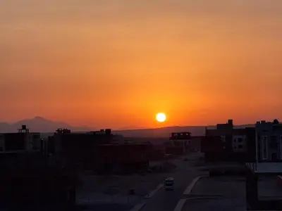 a sunset over a city with a road and buildings at Luxury Arabic Romantic Studio with its own large private Roof Terrace 15 mins from El Gouna in Hurghada
