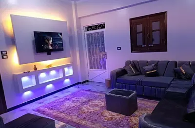 a living room with a couch and a tv at Flower House in Al Aqālitah