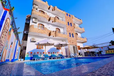 a hotel with a swimming pool in front of a building at Sun wing guest house in Luxor