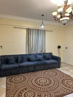 a blue couch in a living room with a rug at شقة ايلا ترافيل in Luxor