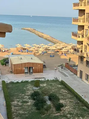 a view of a beach with umbrellas and the ocean at Cozy Seaside 1BR Apartment B4 in Turtles Beach - Hurghada in Hurghada