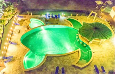 an overhead view of a swimming pool with an umbrella at Cozy Seaside 1BR Apartment B4 in Turtles Beach - Hurghada in Hurghada