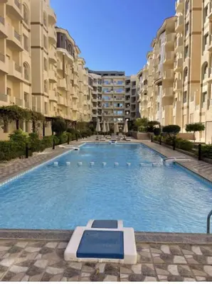 a large swimming pool in front of some apartment buildings at Florenza Khamsin Compound Deluxe Apartment C103 in Hurghada