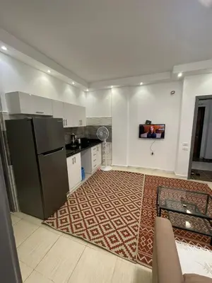 a kitchen with a refrigerator and a kitchen rug at Florenza Khamsin Compound Deluxe Apartment C103 in Hurghada