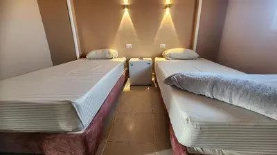 two beds sitting next to each other in a room at Shapon Hotel - Hurghada in Hurghada
