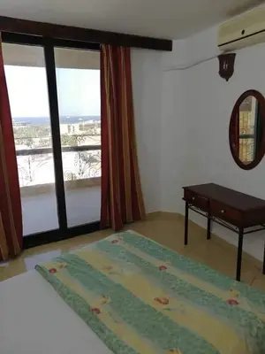 a room with a large window with a table and a rug at Gomla Flats in Hurghada