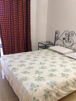 a bed in a bedroom with a blanket on it at Gomla Flats in Hurghada