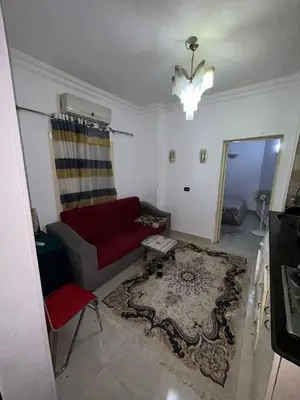 a living room with a red couch and a rug at cleopatra resort in Hurghada