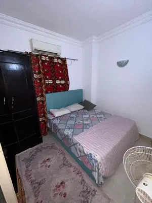 a bedroom with a bed and a dresser at cleopatra resort in Hurghada
