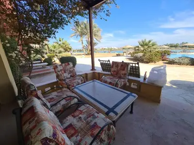 a patio with couches and a table and a pool at ElGouna west golf 2 bedrooms 2 bathrooms - pool in Hurghada