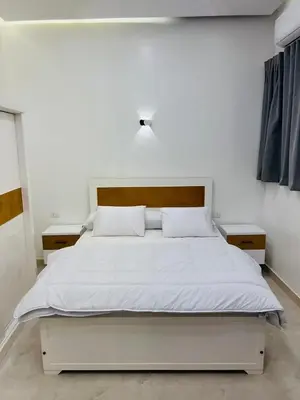 a bedroom with a white bed with two night stands at Twins Villa Luxor in Luxor