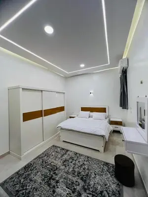 a white bedroom with a bed and a rug at Twins Villa Luxor in Luxor