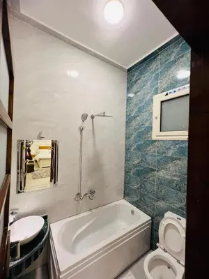 a bathroom with a tub and a toilet and a sink at Twins Villa Luxor in Luxor