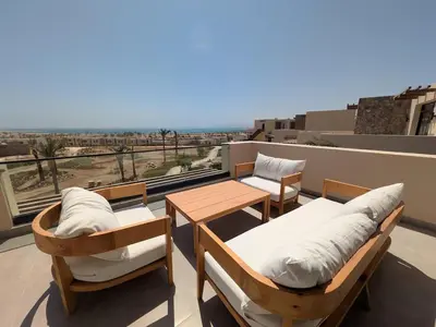 a balcony with two beds and a table and a view at Stunning Penthouse Seaview Apt in Mesca, Somabay in Hurghada