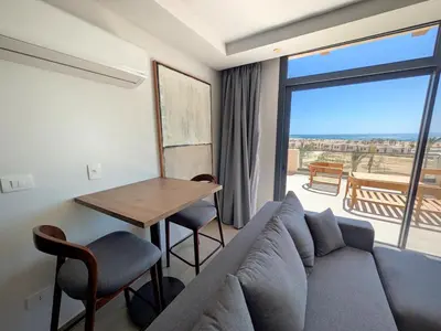a living room with a couch and a table with a view at Stunning Penthouse Seaview Apt in Mesca, Somabay in Hurghada