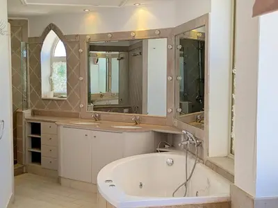 a bathroom with a tub and two sinks and a mirror at Light & Airy Spacious Soma bay Marina 3BR w Sauna & Hot tub in Hurghada