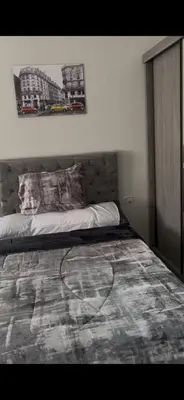 a bedroom with a bed with a picture on the wall at غرفه فندقيه in Hurghada