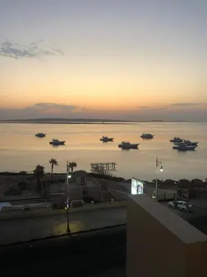 a group of boats in the water at sunset at Luxury apartment with sea view and private beach in Hurghada