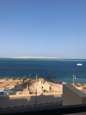 a view of the beach and the ocean from a building at Luxury apartment with sea view and private beach in Hurghada