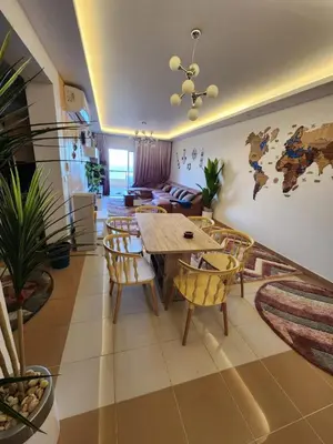 a living room with a table and chairs and a couch at Luxury apartment with sea view and private beach in Hurghada
