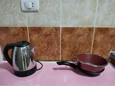a tea kettle and a pan sitting on a stove at room 4 a room in Hostel of 4 rooms in Hurghada