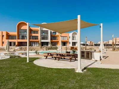 a picnic shelter with a picnic table in the grass at Gouna Ground-Floor Stylish 2Bdr in Hurghada