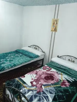 two beds sitting next to each other in a room at Sun Rise House Luxor in Al Aqālitah