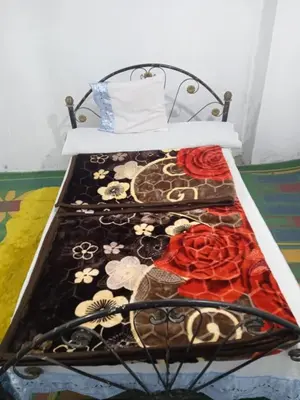 a bed with a bedspread with flowers on it at Sun Rise House Luxor in Al Aqālitah
