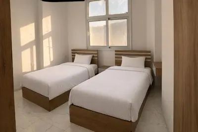 two beds in a room with two windows at La prestigia Hurghada Apartment by Hurghada Concierge in Hurghada