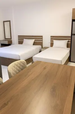 a room with two beds and a wooden table at La prestigia Hurghada Apartment by Hurghada Concierge in Hurghada