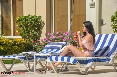 a woman sitting in a chair on a beach chair at Rivoli Suites in Hurghada