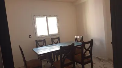 a dining room table with chairs and a window at hurghada , Elhegaz road in Hurghada