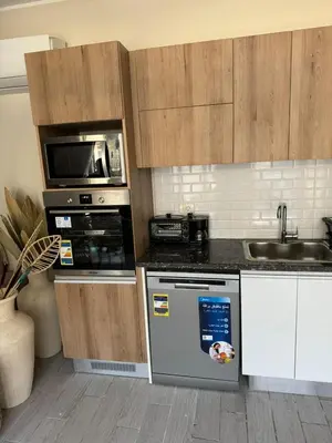 a kitchen with a stove and a microwave at Bali - Elgouna Two Bedrooms private Heated pool in Hurghada