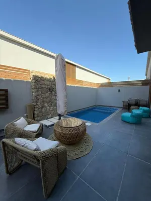 a patio with a table and chairs and a pool at Bali - Elgouna Two Bedrooms private Heated pool in Hurghada
