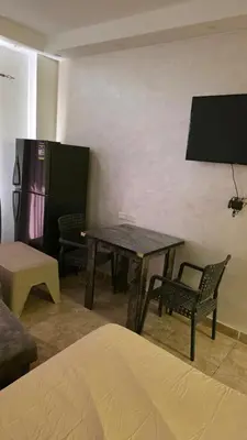 a room with a table and chairs and a tv at florenza-50 in Hurghada