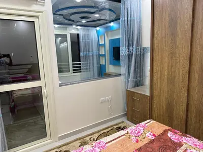 a bedroom with a door with a window and a bed at كورنيش القيادات in Hurghada
