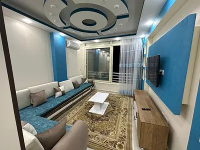 a living room with a couch and a blue wall at كورنيش القيادات in Hurghada