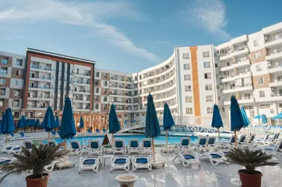 a pool with chairs and umbrellas in a resort at Dive Hostel Hurghada Tiba Golden in Hurghada