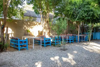 a group of blue tables and chairs under trees at Pharaohs Rest Luxor in Luxor