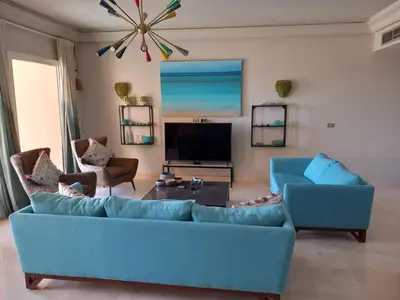 a living room with a blue couch and a tv at Modern Marina View 2 beds apt -New Marina-El Gouna in Hurghada